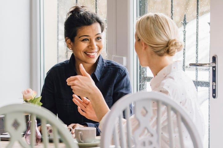 Women are sitting at a table in a cafe.