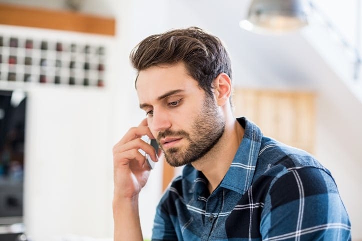 guy talking on phone looking depressed