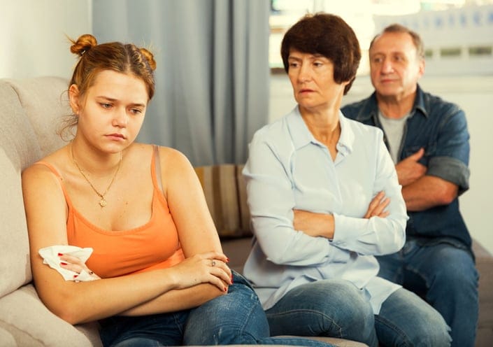 daughter with arms crossed with parents