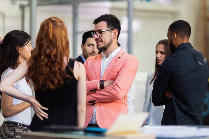 businessman standing too close to female colleauges