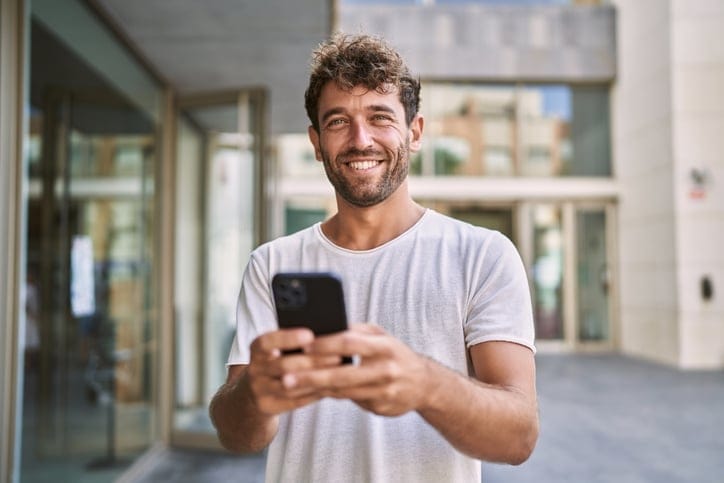 Young man on his phone outside.