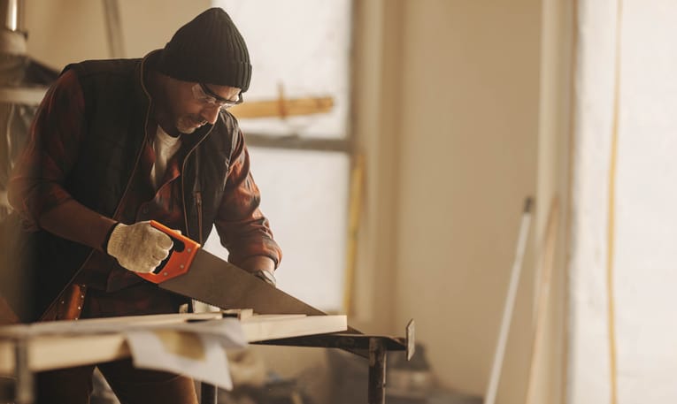 man sawing in workshop