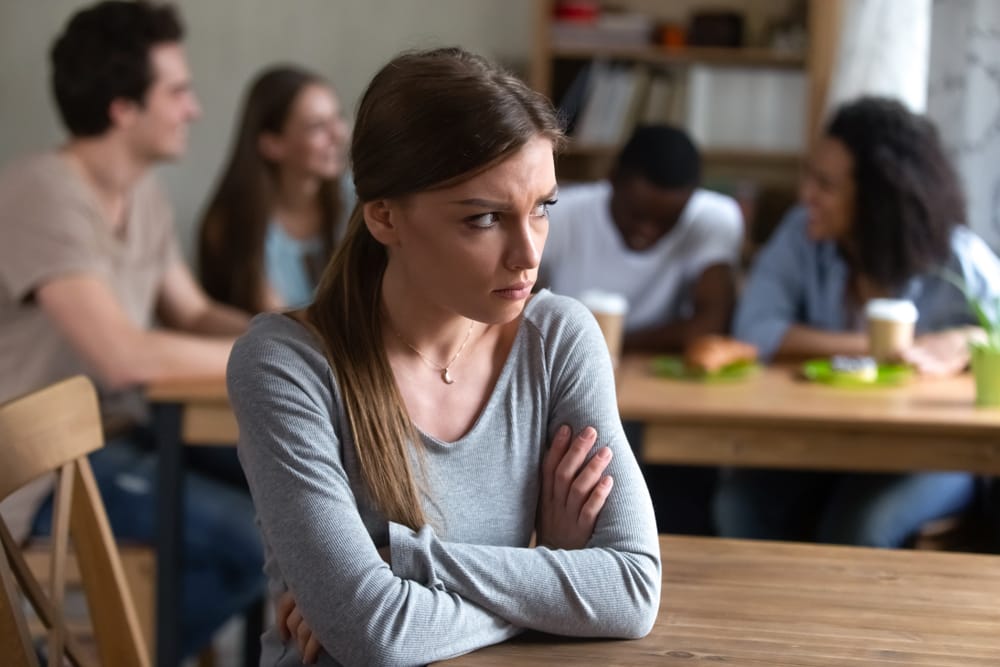 Woman being left out of the group and feeling lonely.