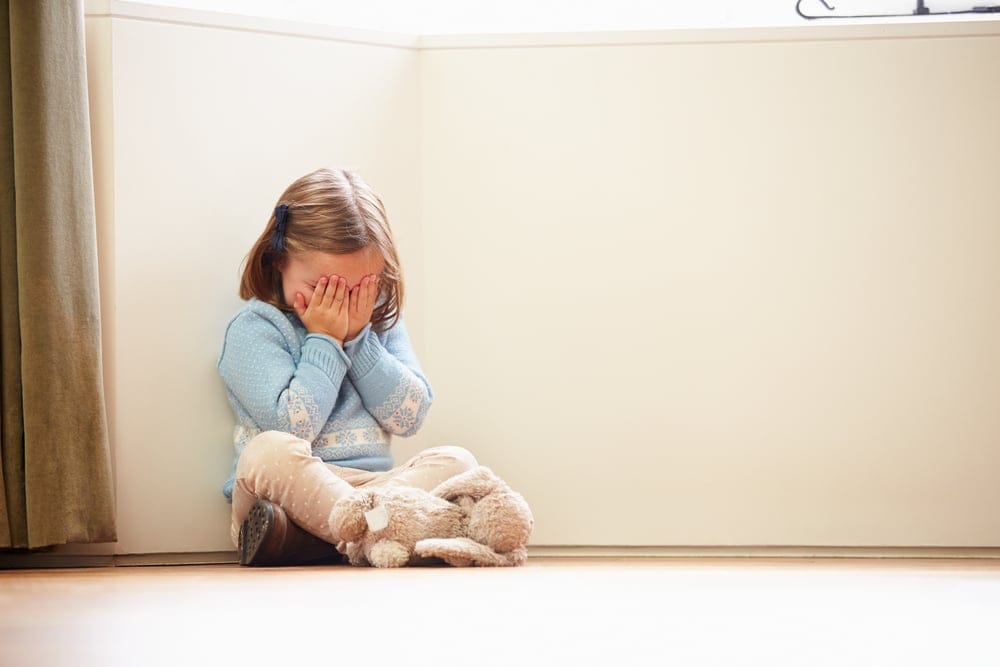 Unhappy child sitting alone.