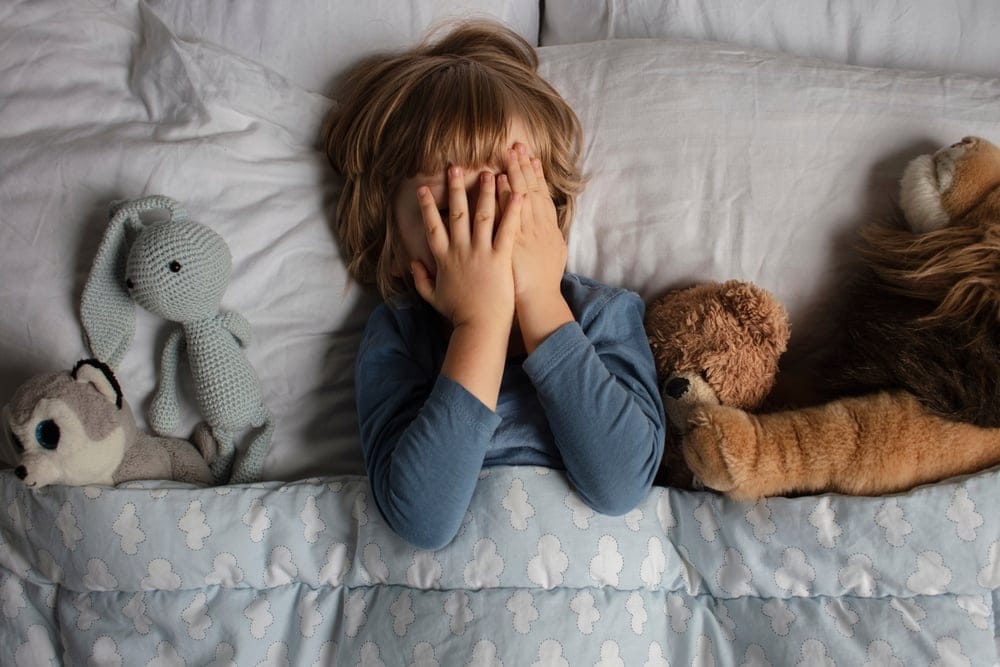Child crying in bed.