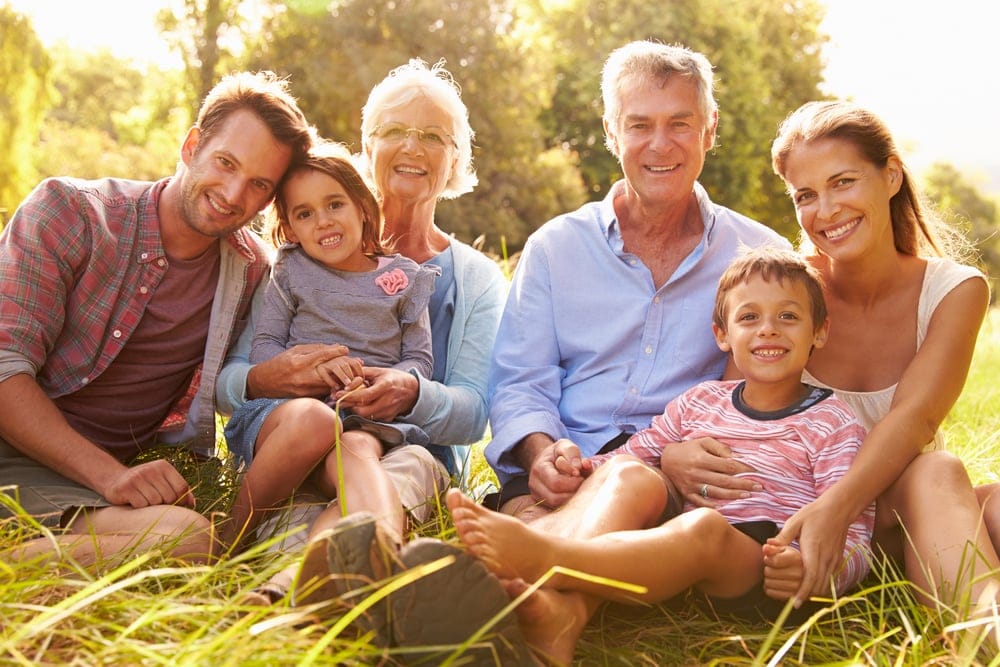Happy family sitting outside on sunny day.
