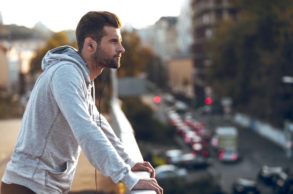Man on the balcony of a city.
