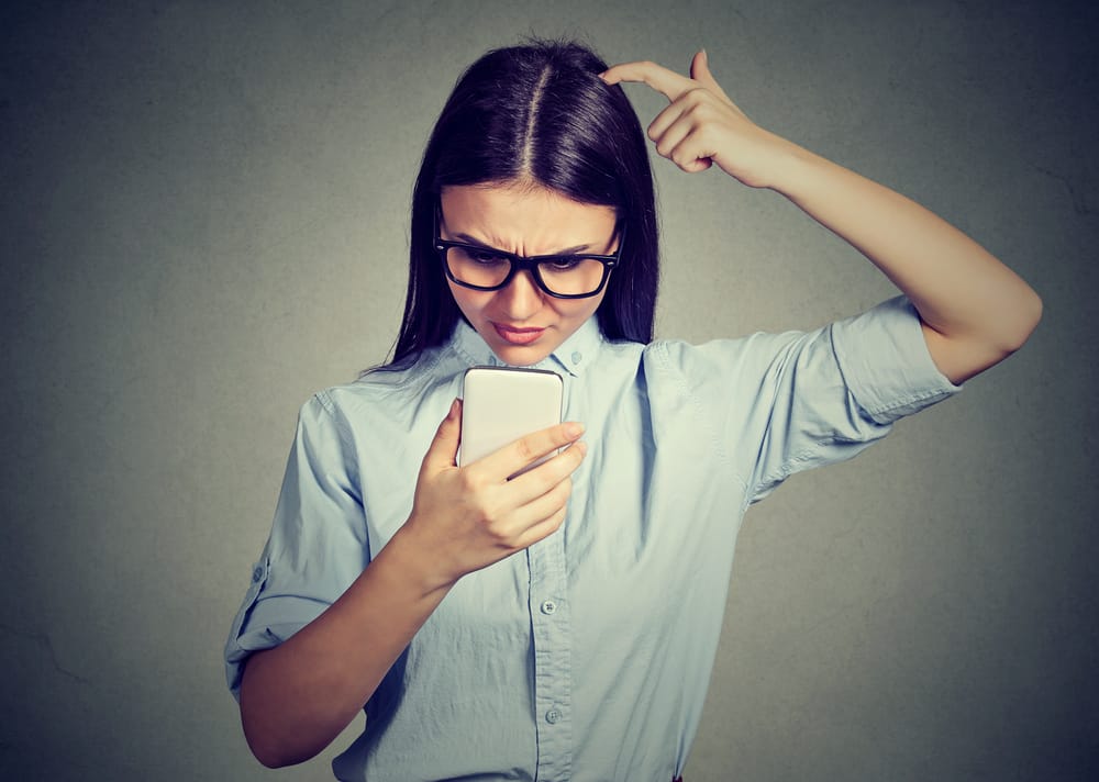 Confused woman checking her phone.