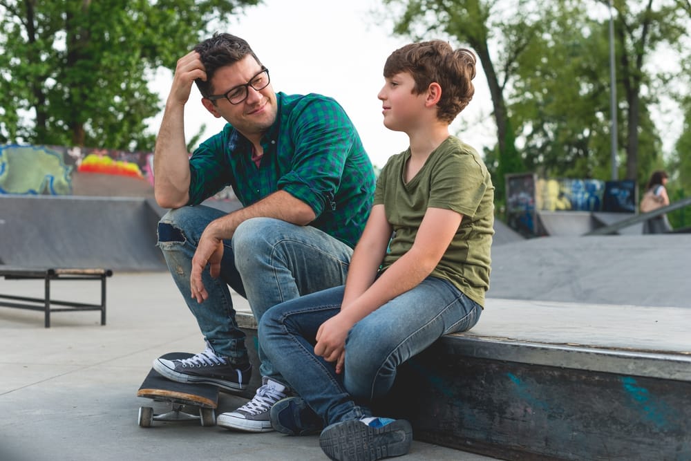 dad talking to son at skate park