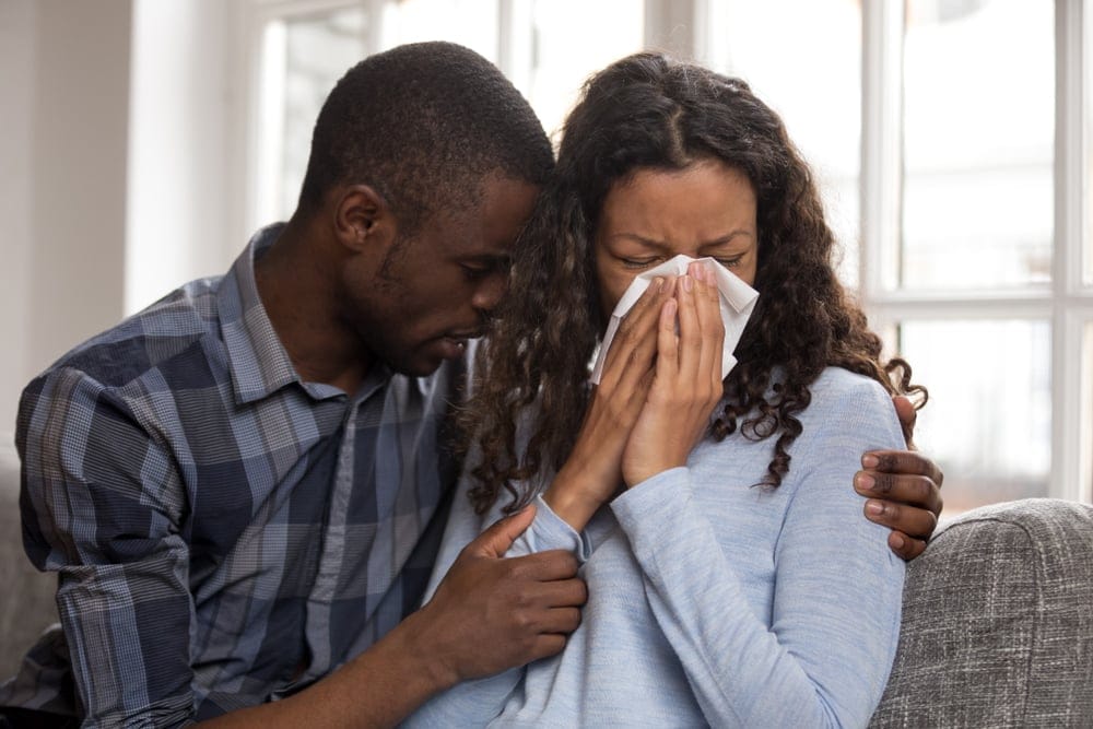 A man tries to comfort a crying woman.