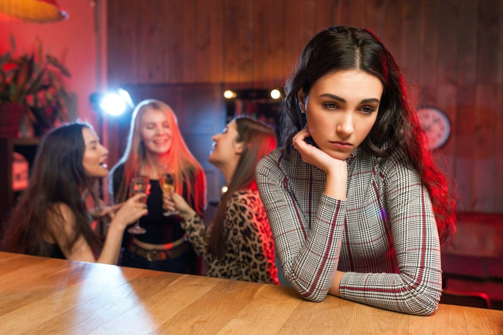 Woman sitting alone at a bar.