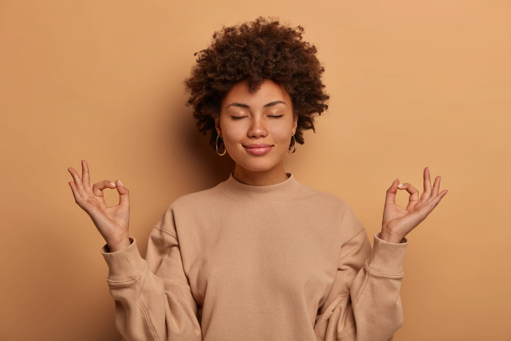 Woman taking deep breaths while meditating.