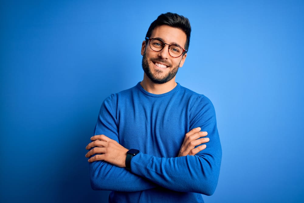 Man smiling in a blue sweater.