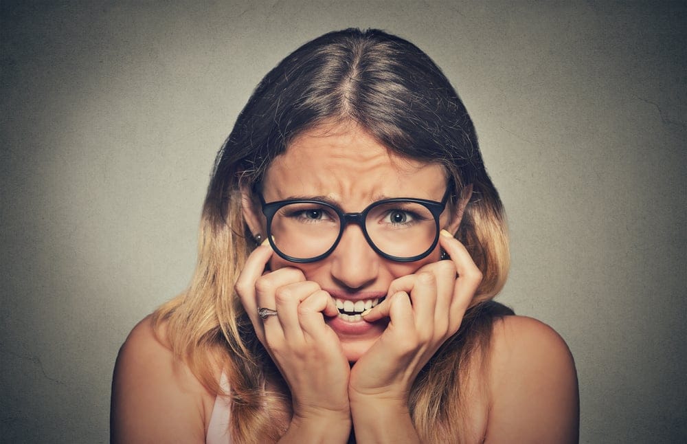 Nervous woman biting her fingernails.