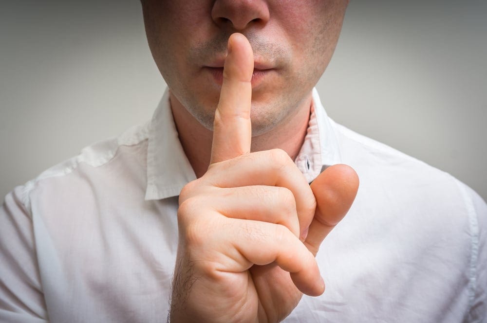 Man shh'ing with his finger to his mouth.