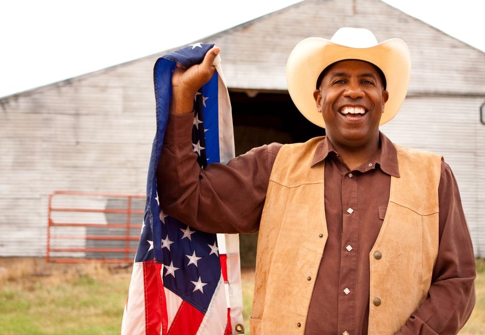 Cowboy holding an American flag.