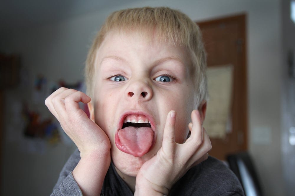 Young boy sticking his tongue out.