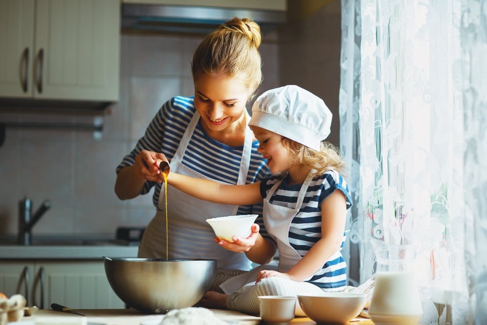 Mon and child cooking in the kitchen.