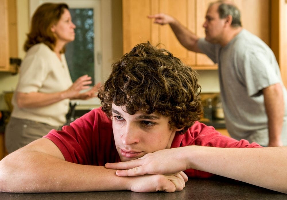 Teenager listening to his parents argue.