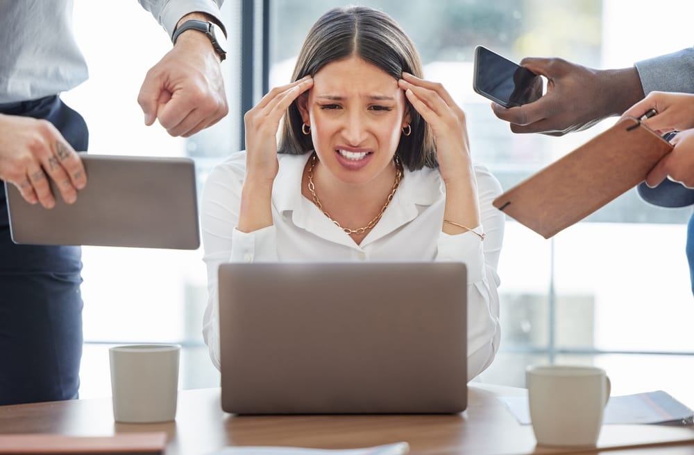 Woman who has a headache from multitasking.