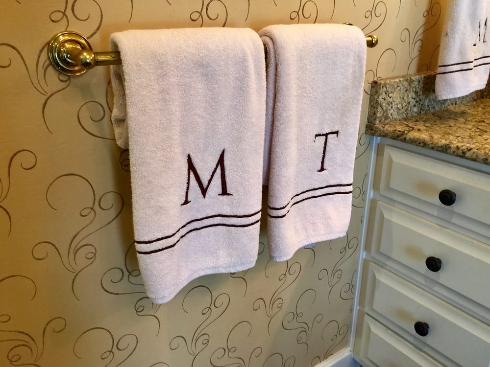 Monogrammed M And T Towels Hanging On A Towel Rod.
