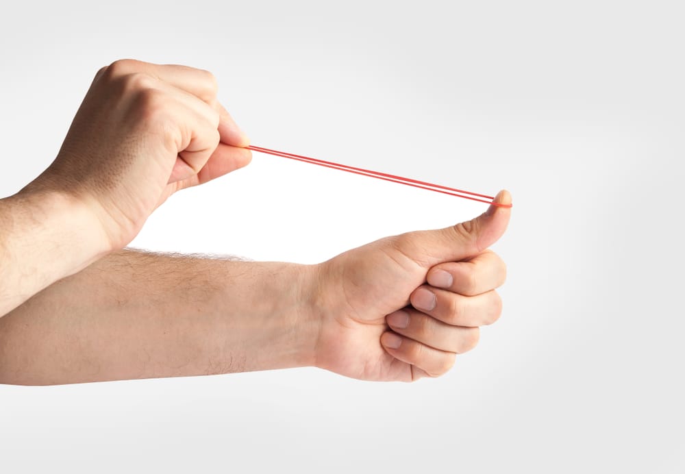 Hands,Stretching,A,Rubber,Band,As,To,Shoot,It,,Isolated
