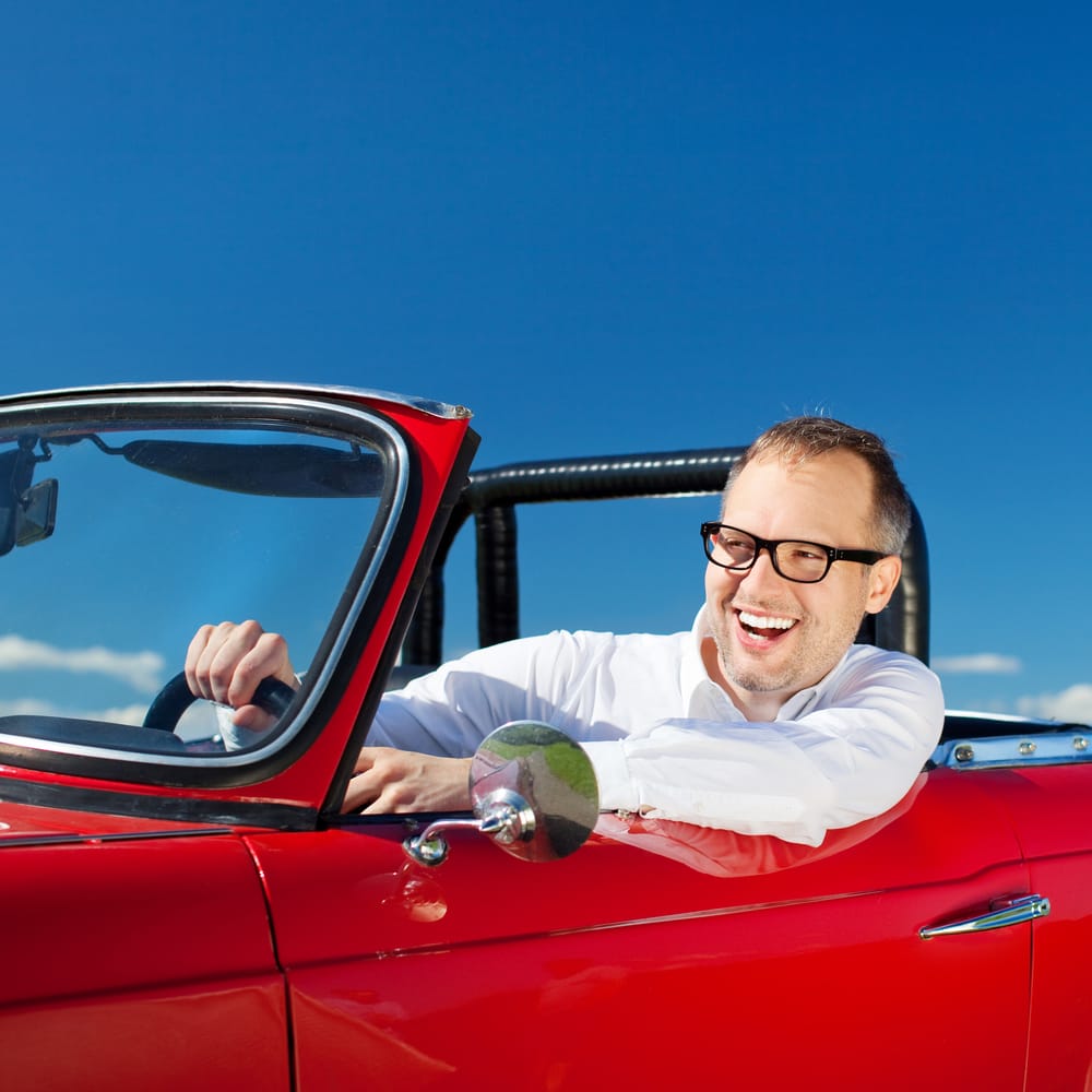 Man in a cool red convertible.