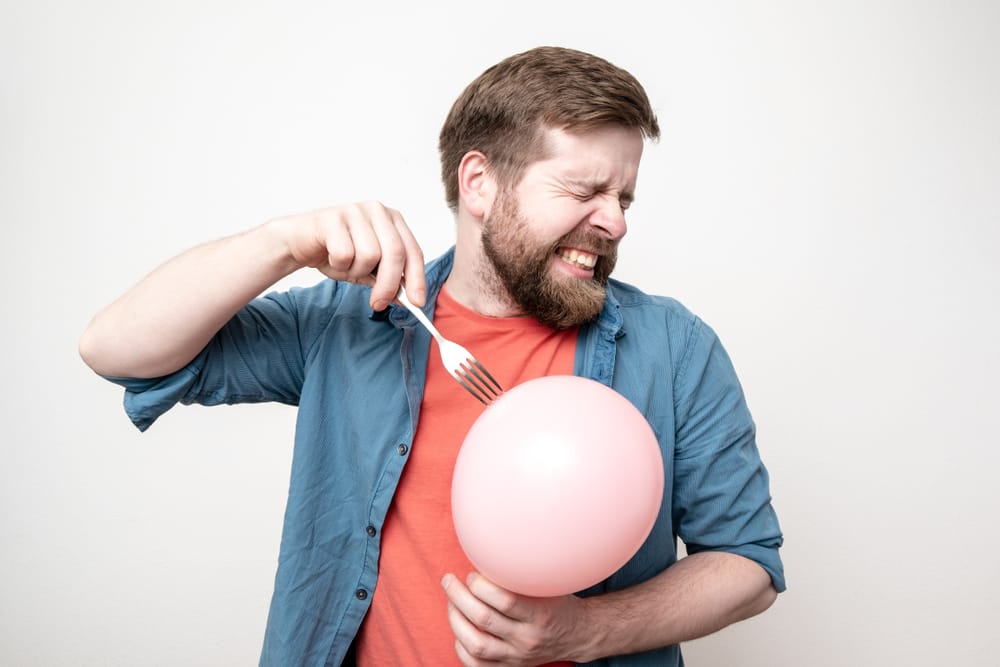 Bearded,Man,Is,About,To,Burst,A,Balloon,With,A