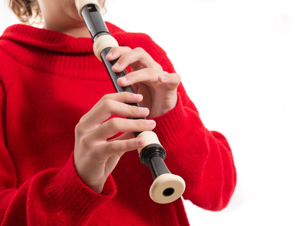 Teenage girl playing the recorder.