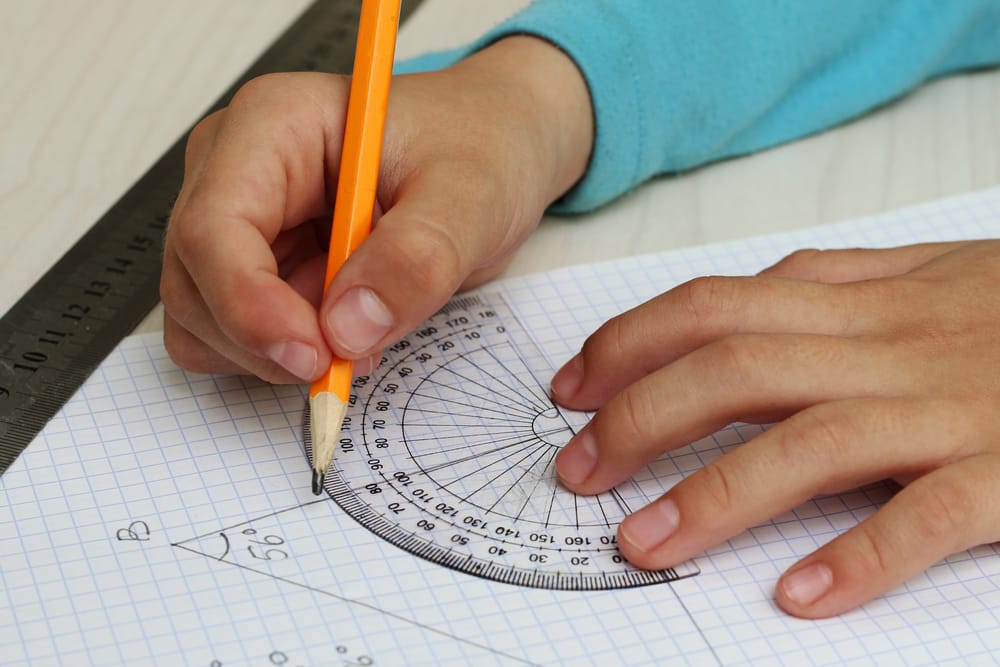 Child's hands with a protractor.