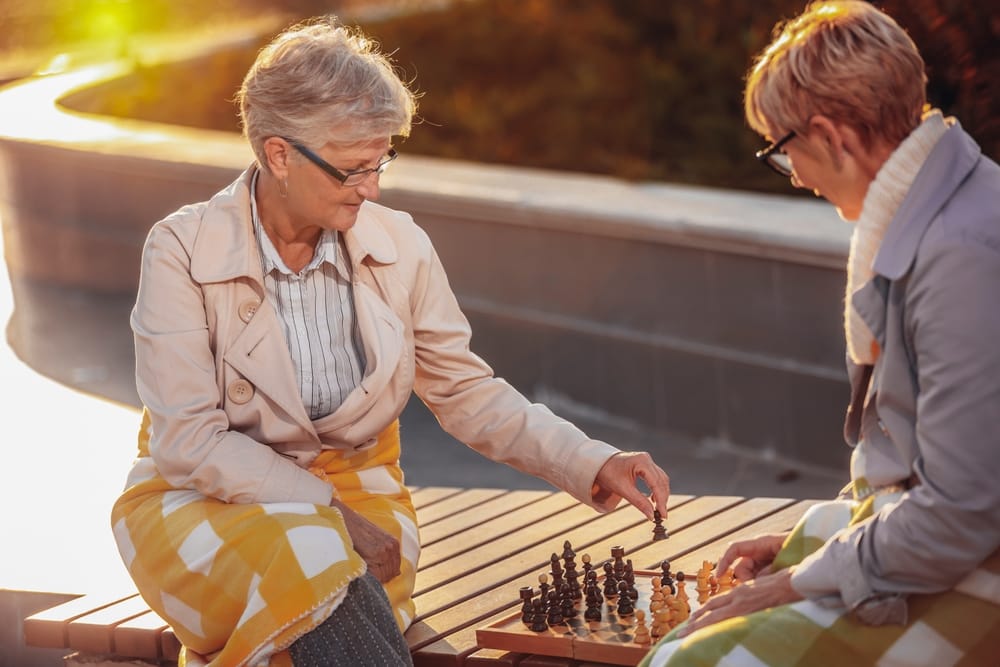 Two older women playing chess.