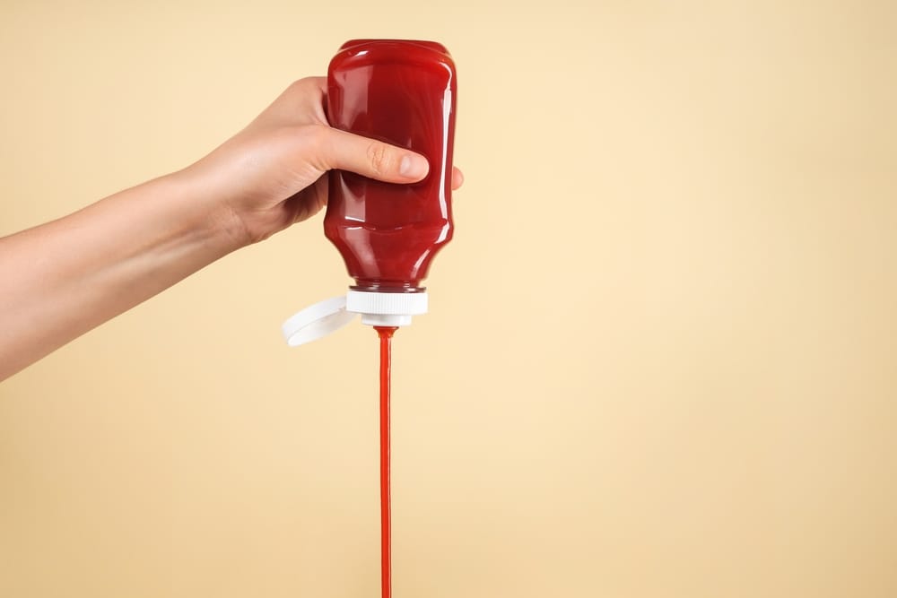 Woman pouring ketchup.