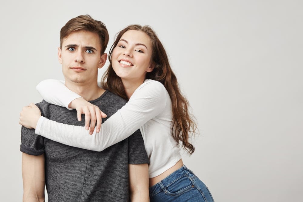 Clingy girlfriend with annoyed confused boyfriend