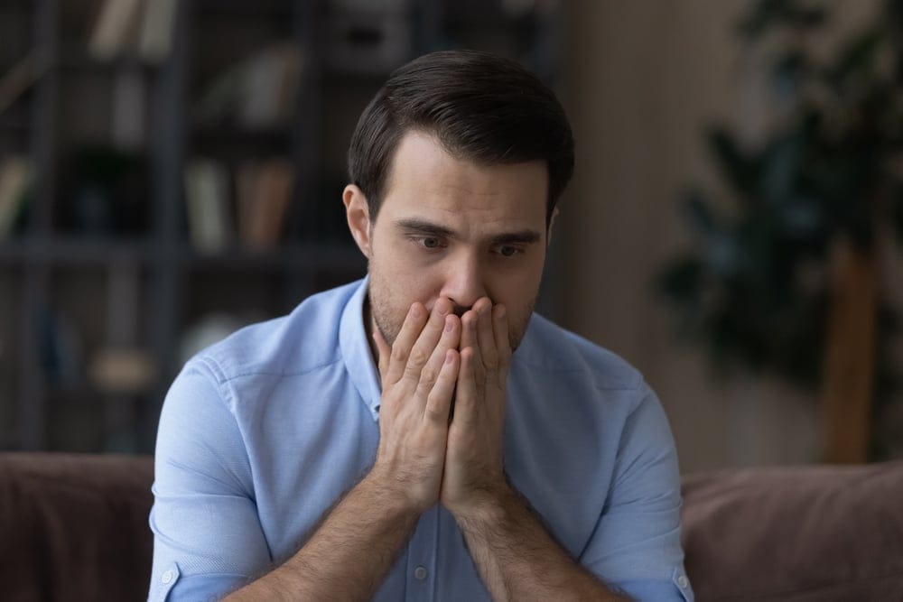 What,To,Do.,Worried,Nervous,Millennial,Man,Covering,Mouth,With