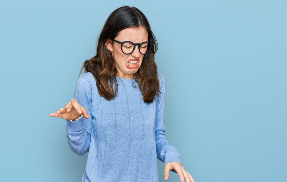 Young beautiful woman wearing casual clothes and glasses with disgusted expression,