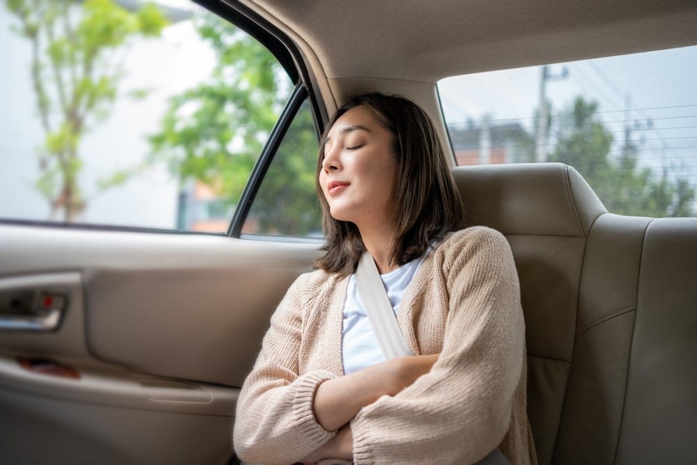 Woman relaxing in the back of a car.