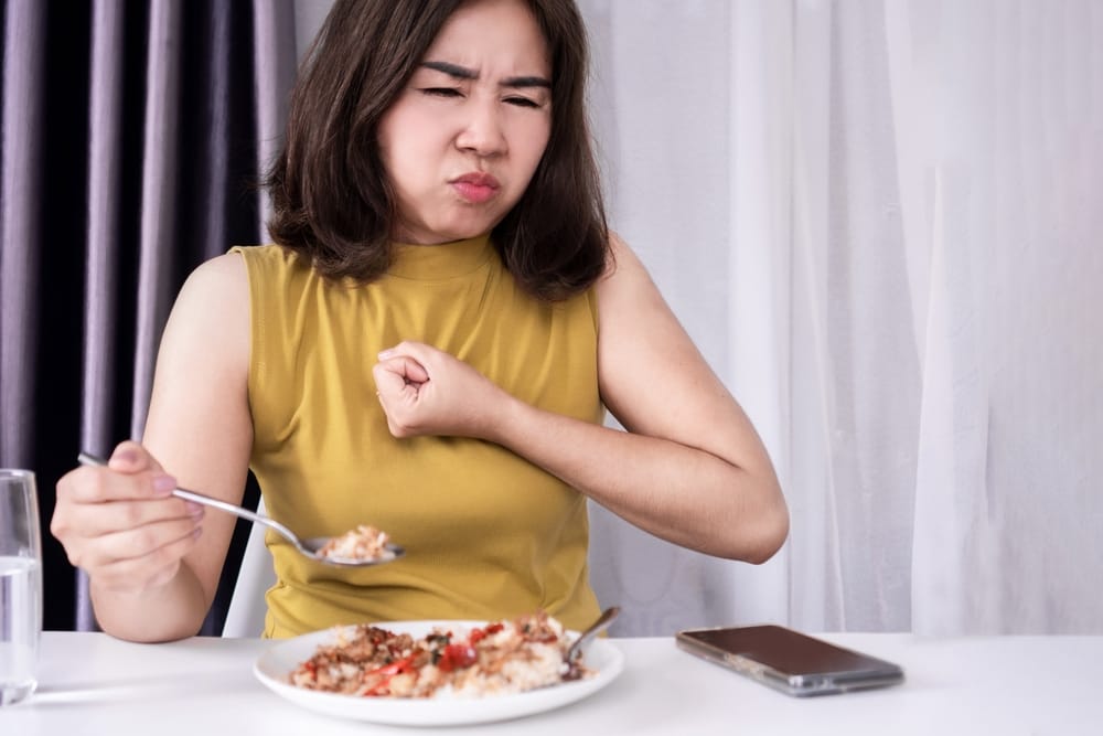 Woman with indigestion after a meal.