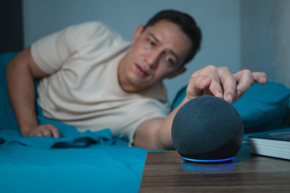 Man reaching for his bedside gadget.