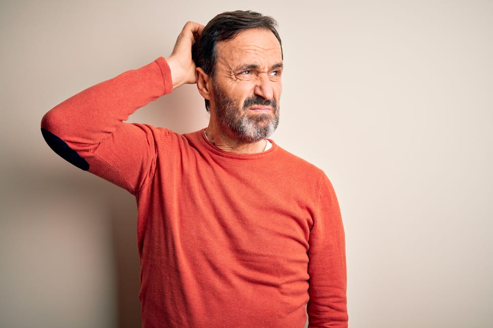 Man scratching his head in doubt.