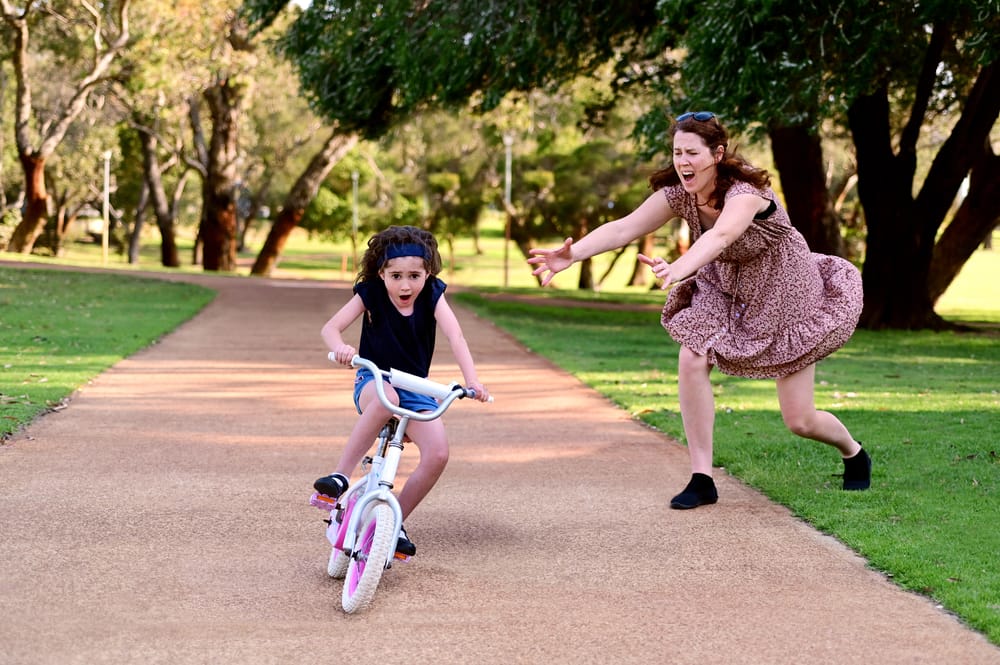 Woman worried about her daughter riding a bike.