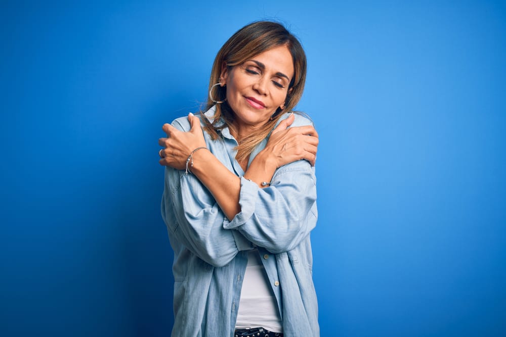 Woman giving herself a hug.