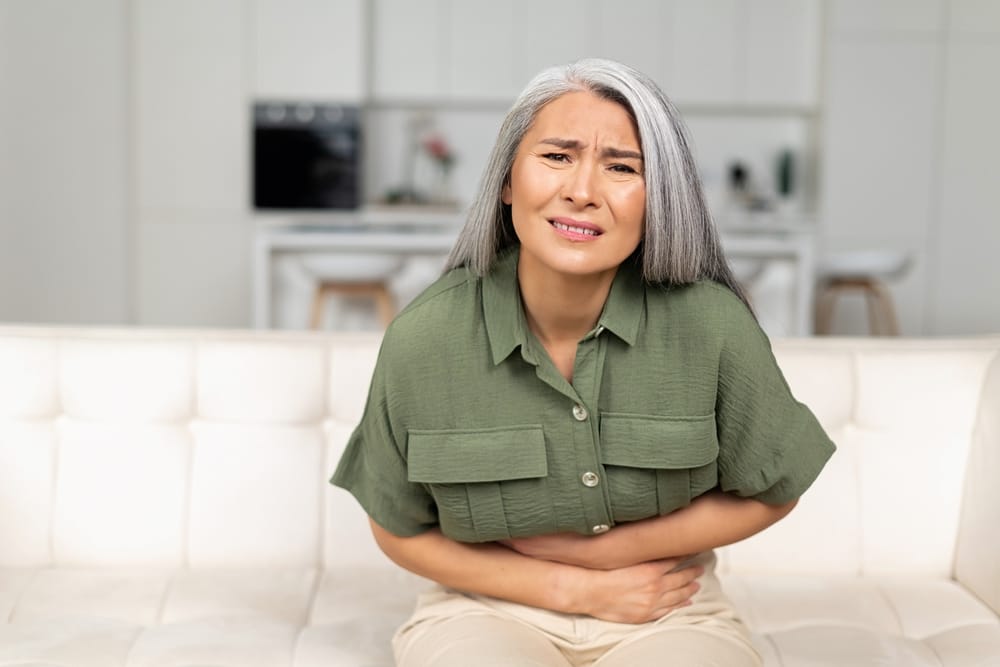 Woman holding her stomach in pain.