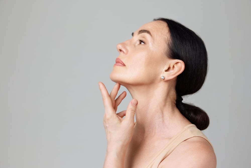Woman applying perfume to her neck.