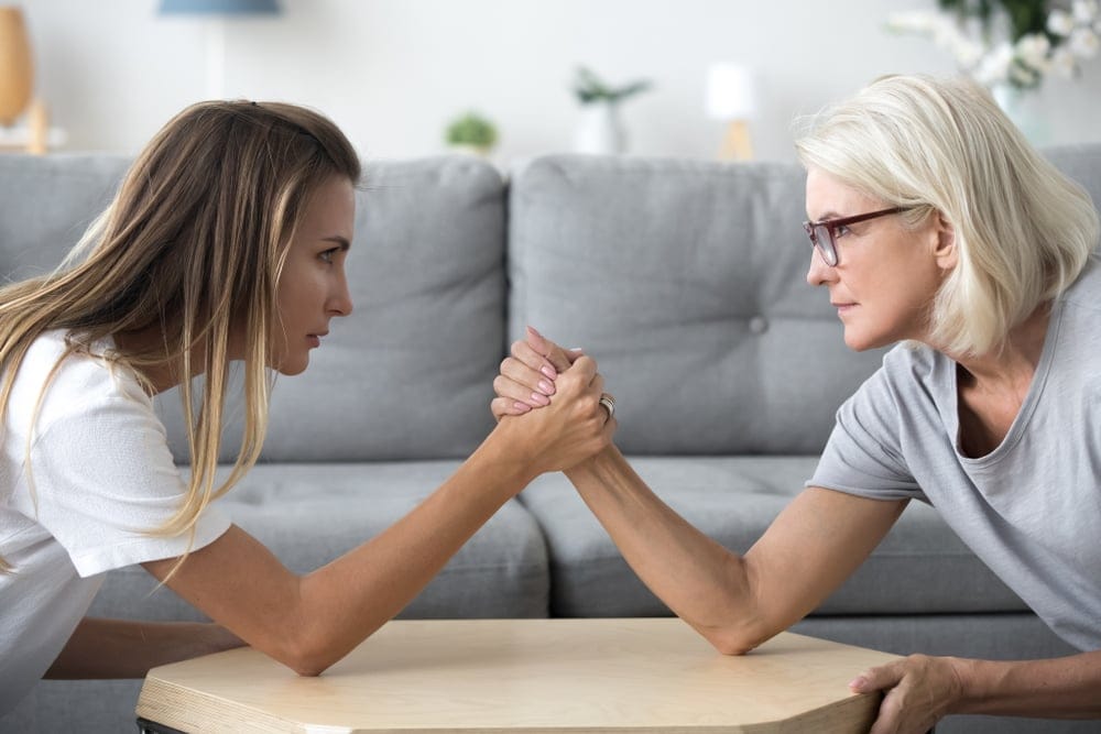 Mother and daughter arm wrestling.