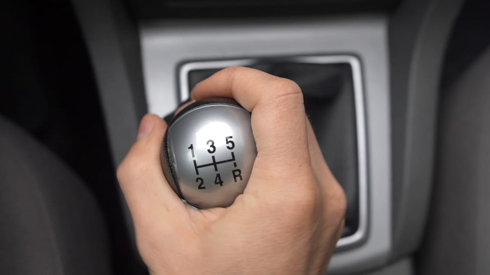 Man's hand on the stick shift of a car.