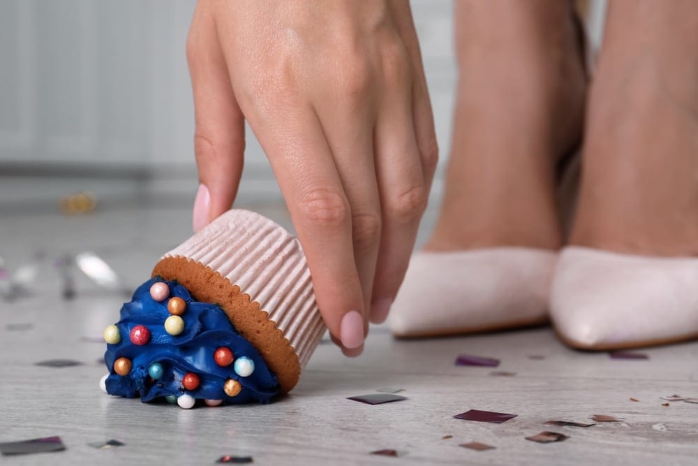 Woman in high heels who dropped a cupcake.