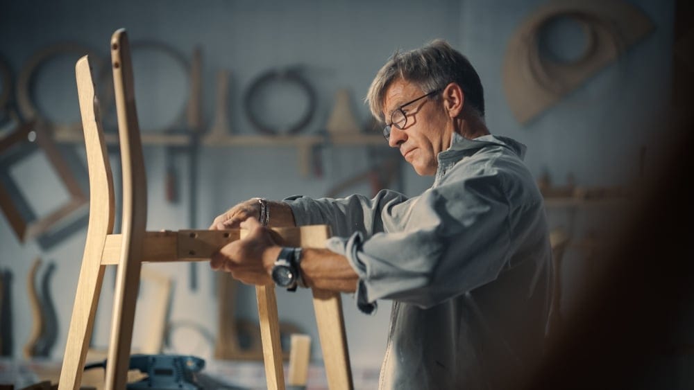 Man woodworking on a chair.