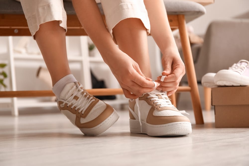 Woman putting on her sneakers.
