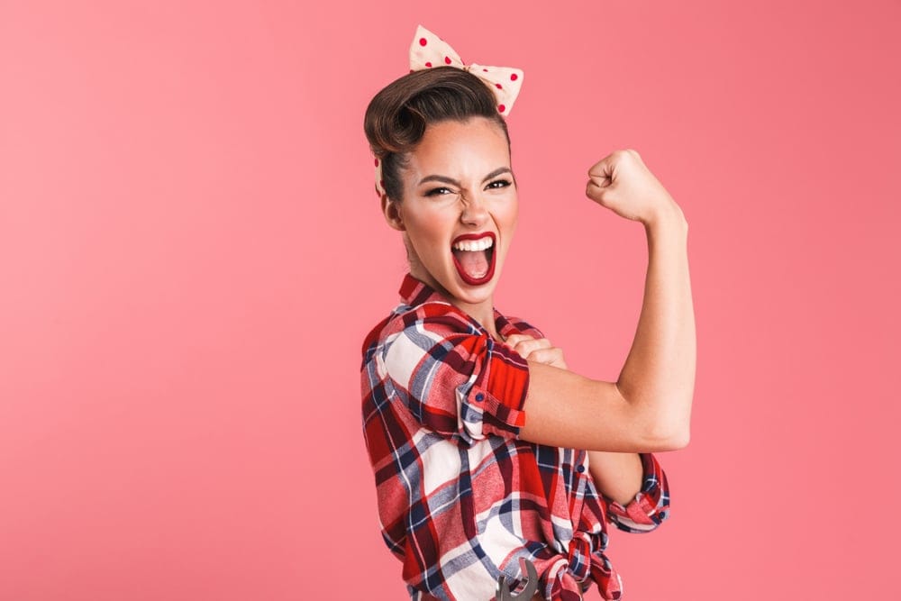 Woman flexing her muscle looking strong.