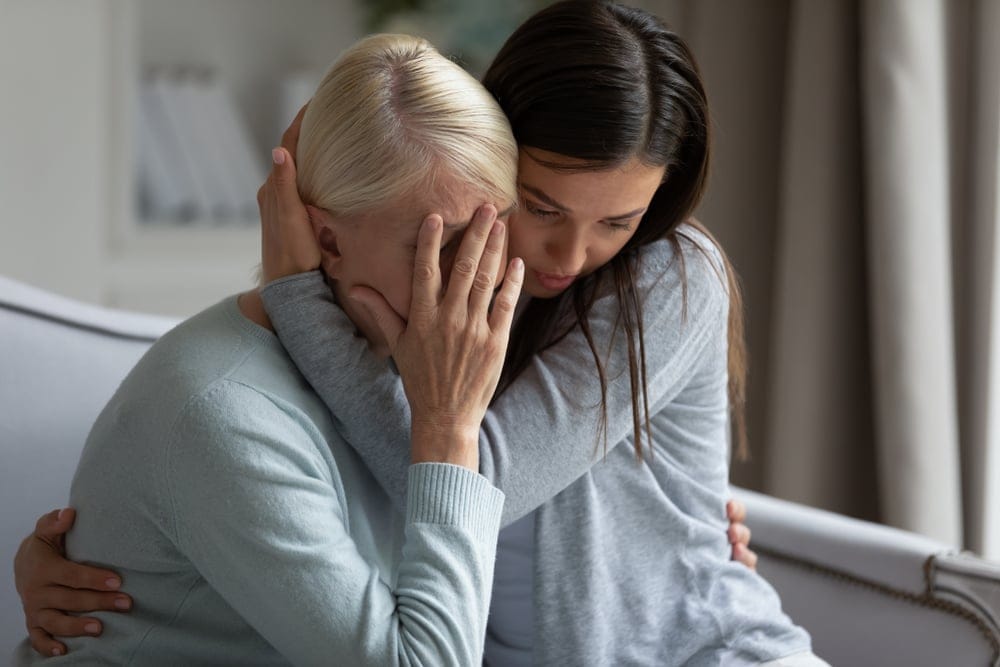 Two woman hugging.